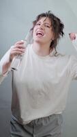 Morning hygiene with fun vibes woman uses a water flosser smiling and dancing turning tooth care into a mini concert at home. video