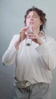 Woman shows how to combine dental care and good mood singing and dancing while using a water flosser at home every morning. video