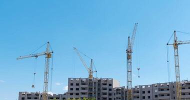 Time-lapse of four large cranes dancing together at a construction site. video