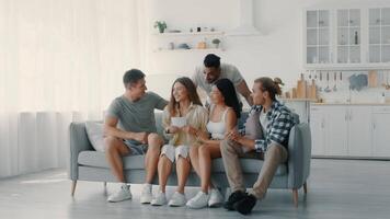 A group of diverse friends shares laughter and stories in a cozy living room. They engage in fun activities, creating joyful moments together in a bright, inviting atmosphere. video
