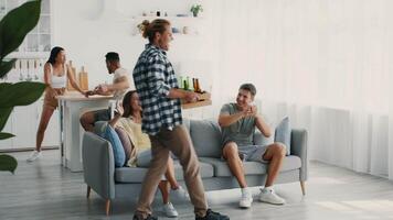 A group of diverse friends gathers in a stylish, well-lit living space, sharing laughter and drinks. They engage in lively conversation while enjoying each other's company and the relaxed atmosphere. video
