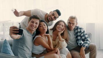 cinco diverso amigos reunir para un divertido día a hogar, compartiendo la risa y juguetón autofotos ellos disfrutar cada otros empresa mientras creando perdurable recuerdos en un relajado atmósfera. video