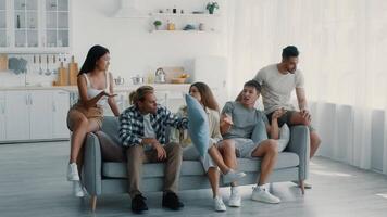 A group of diverse friends have intense conversation together in a bright living room, solving problem video
