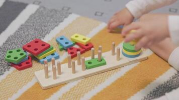 Toddler playing with geometric shape sorter on play mat video