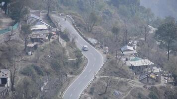 A road with houses on the side and a car driving down it video