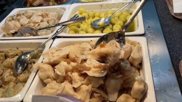 dumplings in the buffet woman puts food on her plate in a buffet. Self service all inclusive restaurant video