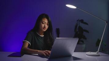 A woman is using a laptop under a lamp video