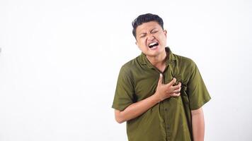 Young Asian man showing symptoms of heart pain and discomfort isolated on white background photo