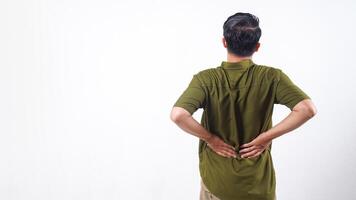Rear view of man suffering from back pain, holding his lower back isolated on white background photo