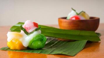 A beautiful and delicious traditional Indonesian snack called Kue Putri Mandi on banan leaf isolated on white background photo