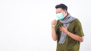Sick man in protective mask and wearing wool scarf struggling with cough isolated on white background photo