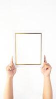 Hand holding empty white colored wooden photo frame isolated on white background
