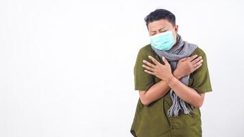 Sick man in protective mask and wearing wool scarf showing fever symptoms isolated on white background photo