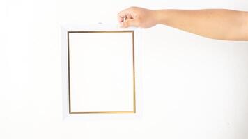 Hand holding simple white colored wooden photo frame isolated on white background