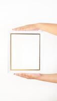 Hand holding white colored wood picture frame isolated on white background photo