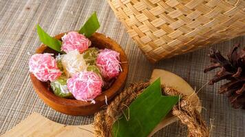 A traditional Indonesian snack food with chewy texture called Cenil on wooden bowl isolated on white background photo