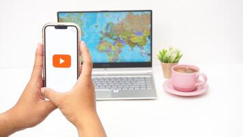 Yogyakarta, Indonesia, 2025 - Man open Youtube platform application on the smartphone isolated on white background photo