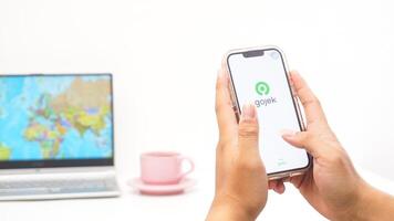 Yogyakarta, Indonesia, 2025 - Man holds smartphone showing Gojek, on-demand service platforms in Indonesia application on the screen isolated on white background photo