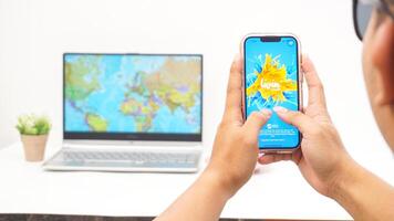 Yogyakarta, Indonesia, 2025 - Man holds smartphone with Livin' by Mandiri digital or mobile banking application on the screen isolated on white background photo
