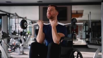Man in wheelchair training biceps with curl bar video