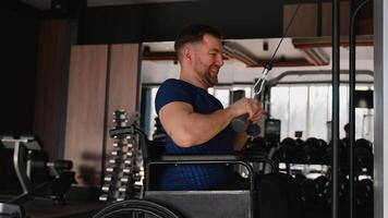 Man in wheelchair using cable machine in gym video