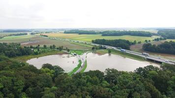 Aerial view of flooded fields and submerged rural road near busy highway video