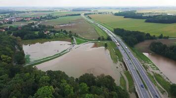 Flooded fields and submerged rural road near busy highway video