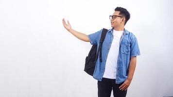 Portrait of smiling young Asian male university student in casual outfit with backpack isolated on white background with copy space photo