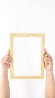 Hand holding empty wood photo frame isolated on white background