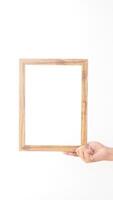 Hand holding simple wooden photo frame isolated on white background