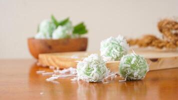 A traditional Indonesian snack made from green sticky rice balls and rolled in grated coconut called Klepon isolated on white background photo