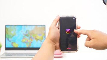 Yogyakarta, Indonesia, 2025 - Man holds smartphone with Instagram application is loaded on the screen isolated on white background photo
