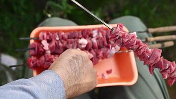 A person is holding a skewer with meat on it video