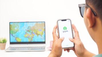 Yogyakarta, Indonesia, 2025 - Man holding smartphone with Gojek, on-demand service platforms in Indonesia application is loaded on the screen isolated on white background photo