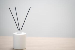 perfume for home. aromatic reed diffuser with sticks and flowers in a vase on a wooden table. the concept of tranquility, relaxation and enjoyment photo