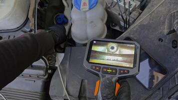 Mechanic using inspection camera to examine internal engine components, diagnostic borescope shows real-time view of cylinder wall with visible damage video