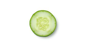 Top view of cucumber slice placed on white background for vegan and vegetarian meal visuals photo