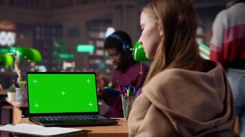 University scholar writes project ideas next to green screen on tablet, gathering citations from reliable books and other sources at the library. Girl consulting the educational materials. Camera B. video
