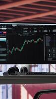 Vertical Modern trading setup with monitor running forex trends going up, high end classy apartment workstation. Clean desk provide a professional space for stock exchange analysis. Camera A. video