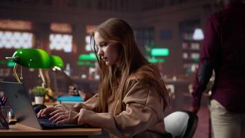 College student captivated by literature assignment at the academic library on campus, working on bachelor degree paperwork. Uses primary source materials from the database. Camera A. video