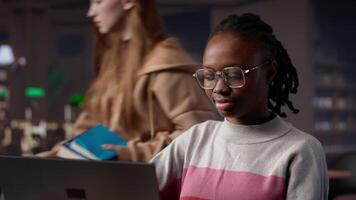 Black girl studying in university library for her bachelor degree diploma, using the educational research collection and general database for knowledge. Collecting citations for paper. Camera A. video