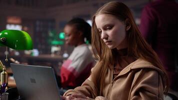 Student struggling to stay focused and awake while she does her research, writing on bachelor paper in the library to obtain college diploma. Girl working hard for a certificate. Camera A. video