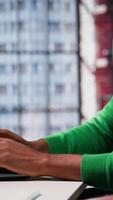 Vertical Young remote worker being pensive thinking about new ideas to make money, using his creativity and innovation for development. African american guy looking for new smart ideas. Camera A. video