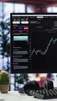 Vertical Empty workspace desktop running day trading stock market trends in stylish apartment. PC used for monitoring investment numbers and candle stick charts, a comfortable environment. video