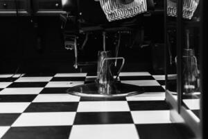 Black and white barber shop interior with checkered flooring and styling chair photo