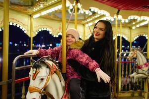 Family enjoyment on a carousel at night carnival in a festive atmosphere photo