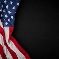 An American flag with white stars on a blue field and red and white stripes is draped over a dark, textured surface. photo