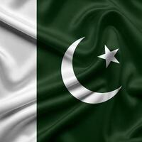 flag of Pakistan, featuring a green field with a white crescent moon and five-pointed star, alongside a white vertical stripe on the left side. photo