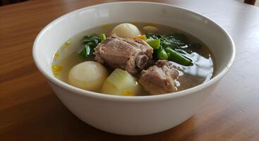 Delicious Sinigang Soup in White Bowl on Wooden Table, Filipino Cuisine photo
