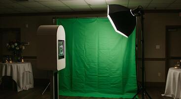 Modern photo booth setup with green screen backdrop for event photography